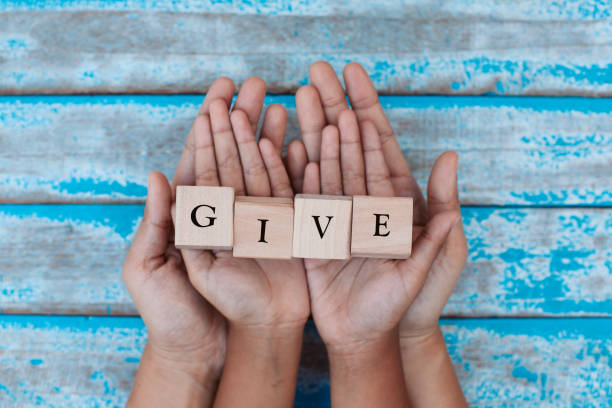 Scrabble Letters that Spell Out Give in a Persons Hand