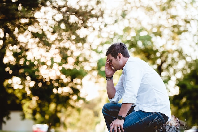 man sitting down in a thinking pose